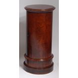 *A Victorian mahogany cylindrical pot cupboard, the blind door opening to reveal shelved interior,