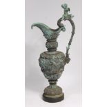 A 19th century continental cast bronze pedestal ewer, the handle surmounted with a winged cherub,