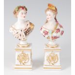 A pair of Meissen Dresden bust figures, each of maidens in the 18th century style,