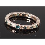 A silver and diamond set eternity ring, arranged as alternating small green and white diamonds,