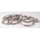 A collection of African tribal silver and white metal bangles, each with chased decoration,