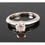 A modern platinum and diamond solitaire ring, the four claw set brilliant weighing approx 0.