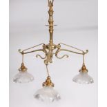 An Art Nouveau lacquered brass three light ceiling pendant, having cut glass suspended shades, h.