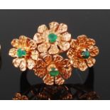 A yellow metal dress ring, the head comprising four textured floral forms,