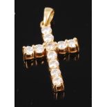 An 18ct gold diamond set cross pendant, the eleven claw set brilliants each weighing approx 0.