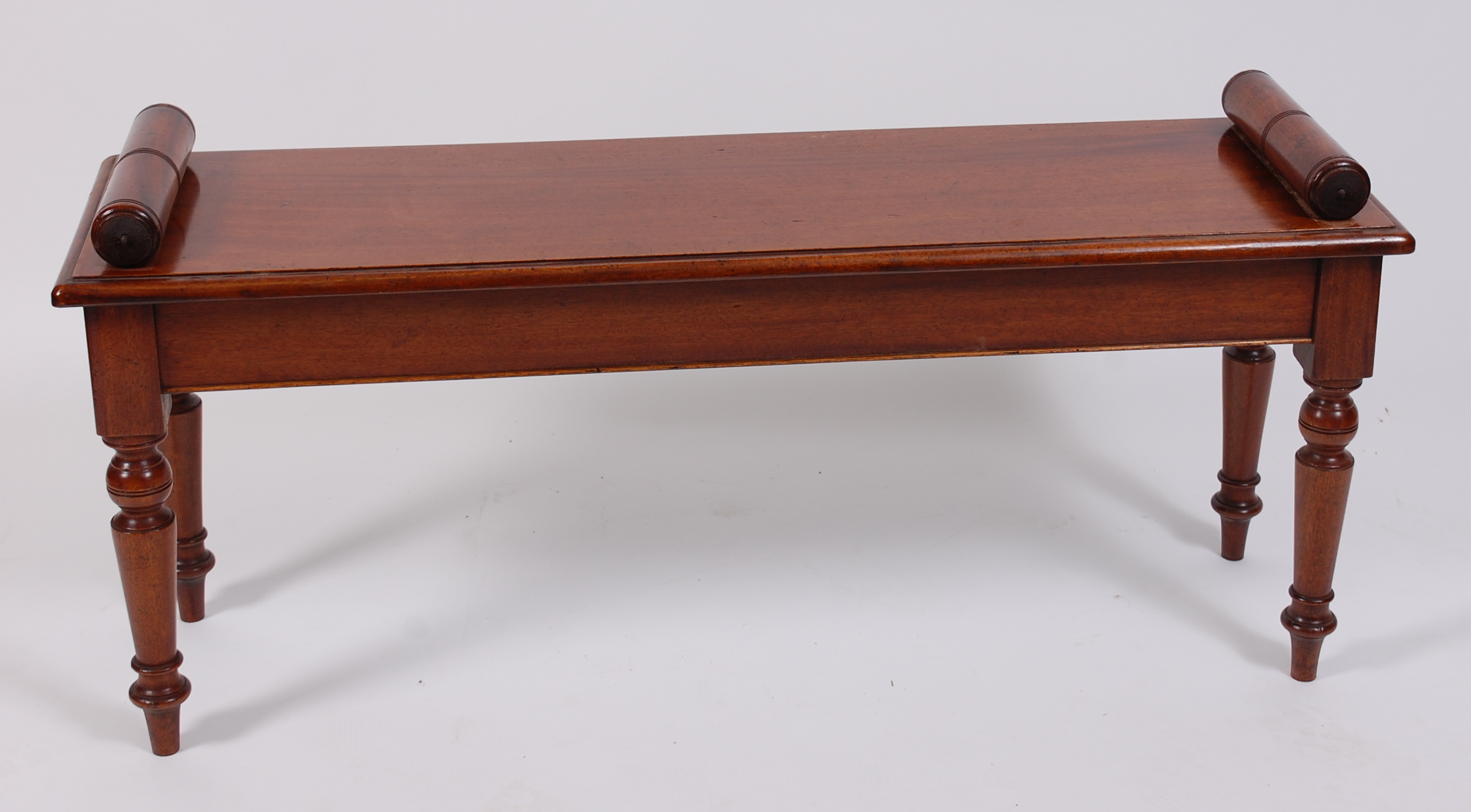 A Victorian style mahogany window seat, raised on ring turned tapering supports, w.112cm, d.33cm, h.