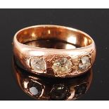 A gents 9ct gold and diamond three stone gypsy ring, the centre set old brilliant weighing approx 0.