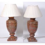 A pair of variegated rouge marble lamps, of classical urn form,