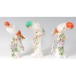 A set of three circa 1900 porcelain parrots, each perched upon a treestump issuing flowers,