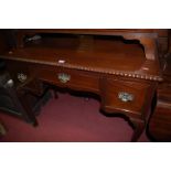 A circa 1900 mahogany three-drawer low boy having a gadrooned edge and raised on cabriole supports,