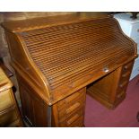 A 1930s oak kneehole rolltop desk, each pedestal fitted with four short drawers. w.