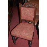 A set of six Edwardian carved walnut and red floral upholstered pad back and seat dining chairs