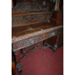 A circa 1900 heavily carved oak two drawer side table having a raised superstructure and green man