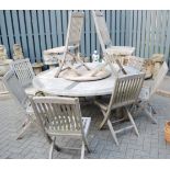 A contemporary slatted teak garden suite, comprising; circular table with rotating centre section,