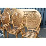 A contemporary wicker conservatory suite, comprising; oval table, six chairs, wicker two-tier stand,