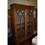 A 1930s oak ledge back double door glazed bookcase,