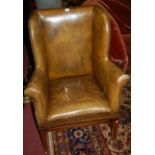 A Georgian style mahogany framed and green leather studded wingback armchair