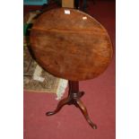 An early 19th century mahogany circular tilt top pedestal tripod table