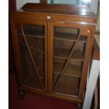 A 1930s oak ledgeback double door glazed bookcase, w.