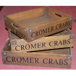 A graduated set of three stained wood and metal bound Cromer Crab trays