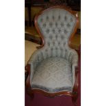 A mid-Victorian faded rosewood(?) framed and green floral buttonback upholstered spoonback armchair,