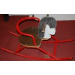 A red painted tubular metal childs rocking horse