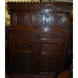 A large antique heavily carved and joined oak court cupboard,