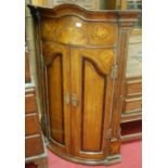 An early 19th century North Country oak and mahogany crossbanded bowfront hanging corner cupboard,