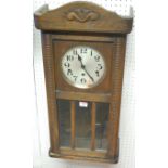 A 1930s oak droptrunk wall clock,