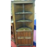 A moulded oak freestanding part open corner cupboard