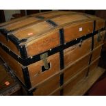 An early 20th century pine and metal bound dome topped travelling trunk having rope twist end carry