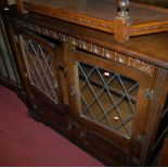 A Stanley Wood oak and lead glazed four door side cabinet,