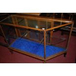 A late Victorian oak and glazed shop display cabinet, having twin rear glazed sliding doors,