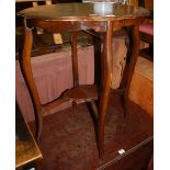 An Edwardian walnut shaped top two tier occasional table