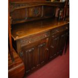 A moulded oak linenfold double door sideboard having twin upper drawers and raised superstructure,