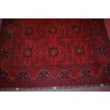 A Persian woollen red ground Bokhara type rug,