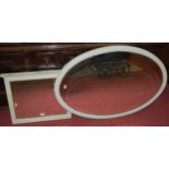 An Edwardian painted bevelled oval wall mirror;