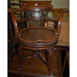 A circa 1900 oak revolving tub desk chair, having dished seat,