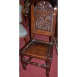 An antique low relief carved and joined oak panelled seat single dining chair