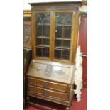 An early 20th century moulded oak bureau bookcase, having twin lancet glazed door upper section, w.