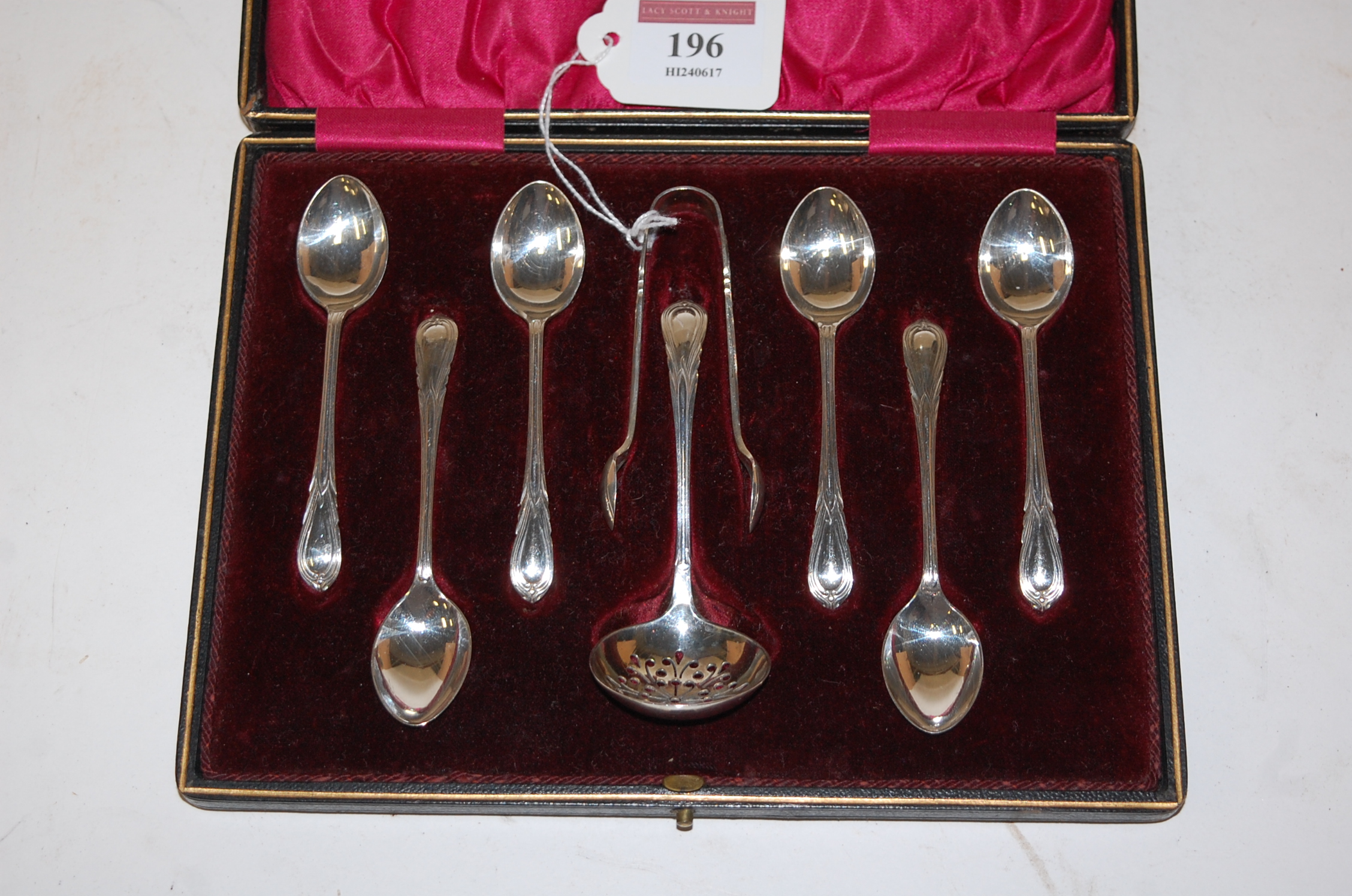 A cased set of six Edwardian silver teaspoons with matching sifting spoon and sugar bows by John