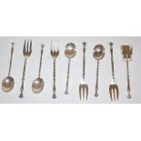 A set of six white metal spoons,