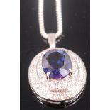 A modern silver pendant four claw set with a large blue stone in a paste set surround and on box