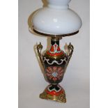 A Victorian stoneware and gilt brass mounted pedestal oil lamp, having an opaque glass shade,