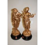 A pair of early 20th century spelter and later gilt painted figures of maidens,