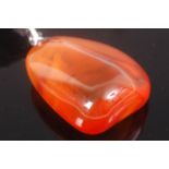 A clear orange amber pendant in natural form approx 25.5g height 5.