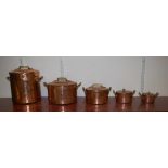 A graduated set of five early 20th century hammered copper twin handled pans with covers, largest h.