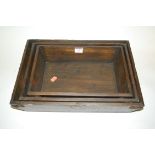 A graduated set of three stained pine and iron mounted trays each bearing a label for A Wallace