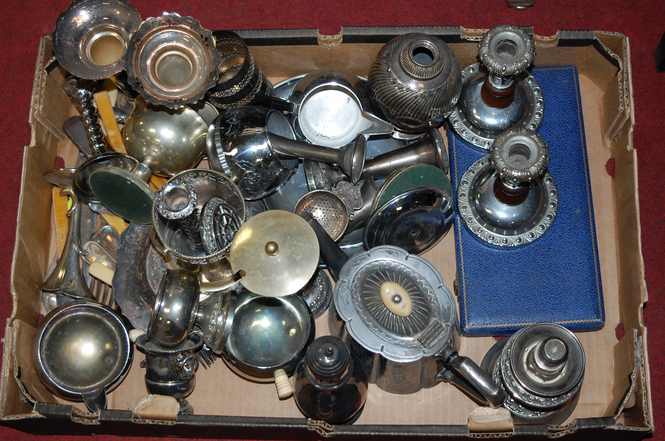 A box of miscellaneous metalwares to include silver plated table candlesticks, goblets,