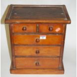 An early 20th century stained pine apprentice piece chest of two short over three long drawers on